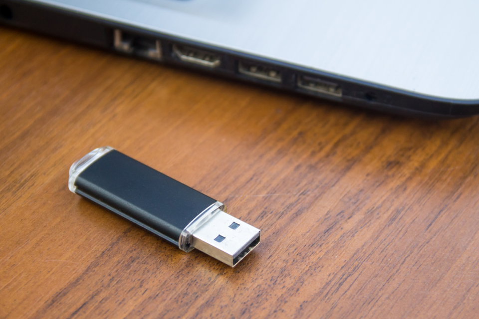 USB-minne ligger intill en dator.